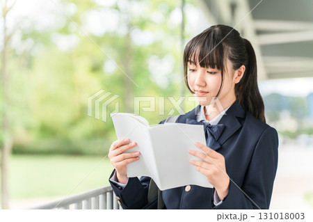 参考書,教科書,問題集を読みながら通学する受験生の女子高生,中学生,高校生 参考書,教科書,問題集を読みながら通学する受験生の女子高生,中学生,高校生 131018003