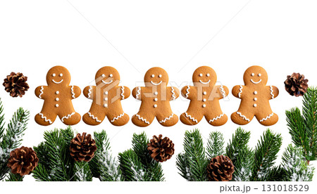 Decorated Christmas gingerbread cookies and pine cones on wooden table isolated on white background 131018529
