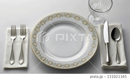 Elegant dining setup featuring fine china and polished cutlery on a table setting in soft light 131021165