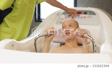 機械浴で入浴介助を受けるアジア人高齢者 機械浴で入浴介助を受けるアジア人高齢者 131022304