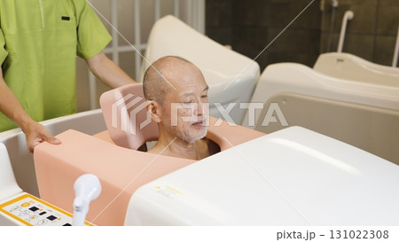 機械浴で入浴介助を受けるアジア人高齢者 機械浴で入浴介助を受けるアジア人高齢者 131022308