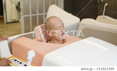 機械浴で入浴介助を受けるアジア人高齢者 131022309