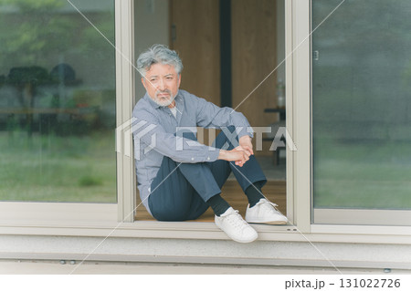 窓の外を眺めるシニア男性 131022726