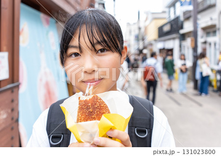 鎌倉観光をしながら食べ歩きをする10代の女性 131023800