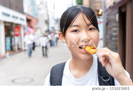 鎌倉観光をしながら食べ歩きをする10代の女性 131023801