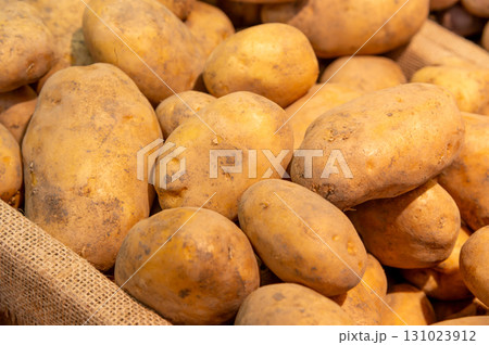 Selected potatoes in a basket at the market. Close-up of large fresh potatoes, the new harvest on the counter 131023912