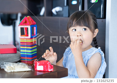 ビスケットを開ける女の子と積み木遊び ビスケットを開ける女の子と積み木遊び 131025235
