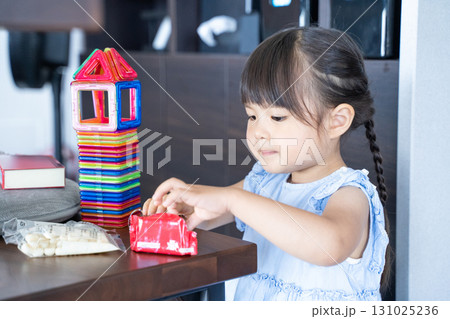 ビスケットを開ける女の子と積み木遊び 131025236