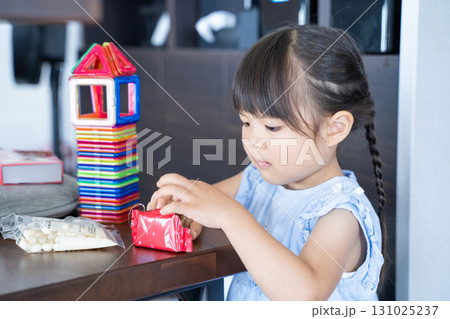 ビスケットを開ける女の子と積み木遊び ビスケットを開ける女の子と積み木遊び 131025237