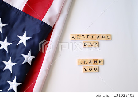 Veterans Day Thank You spelled with wooden letter tiles on American flag, tribute to military service and patriotism Veterans Day Thank You spelled with wooden letter tiles on American flag, tribute to military service and patriotism 131025403
