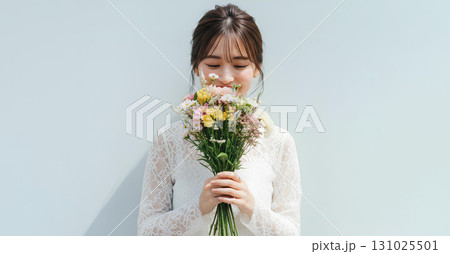 花束を持ち優雅に佇む若い女性のポートレート 131025501