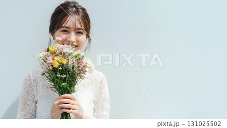 花束を持ち優雅に佇む若い女性のポートレート 131025502