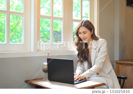 Digital nomad concept, Asian woman working with her laptop in cafe 131025810