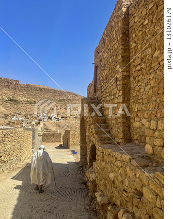 Walking through the historic streets of Toudjane in Tunisia under a clear blue sky 131026179