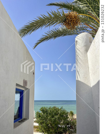 Beautiful view from the white rooftop in Djerba, Tunisia overlooking the sea and palm trees on a Beautiful view from the white rooftop in Djerba, Tunisia overlooking the sea and palm trees on a 131026232