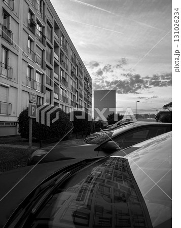 Reflections of buildings on a parked car during sunset in an urban area 131026234
