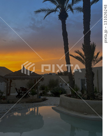 Stunning sunset view over the pool at an Airbnb in Djerba, Tunisia, showcasing vibrant colors and 131026248