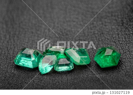 A pile of green gemstones on a black surface 131027119