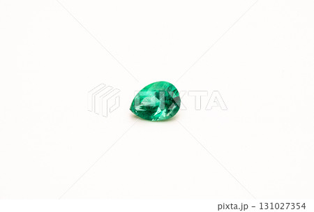 A green gemstone is sitting on a white background 131027354