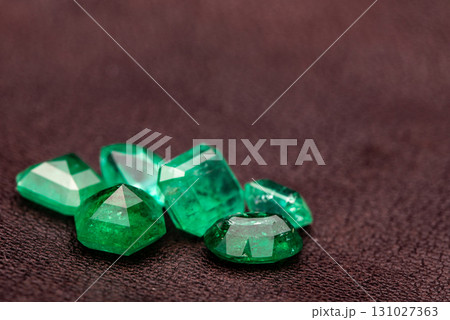 A pile of green gemstones on a dark surface 131027363
