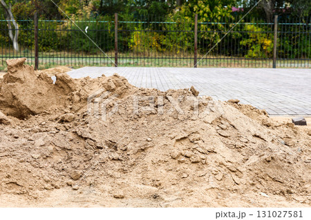 Using Sand for Pathway Construction in an Urban Park: A Close-Up of Sand Being Spread to Create Durable and Attractive Walkways for Visitors 131027581