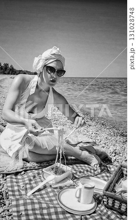 A woman enjoys a seaside picnic, eating spaghetti on a checkered blanket in a vintage style. 131028748