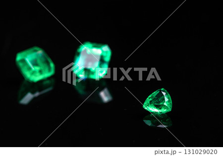 Three green gemstones are on a black background Three green gemstones are on a black background 131029020