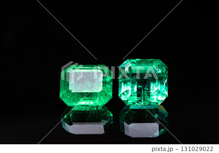 Two green gemstones are displayed on a black background 131029022