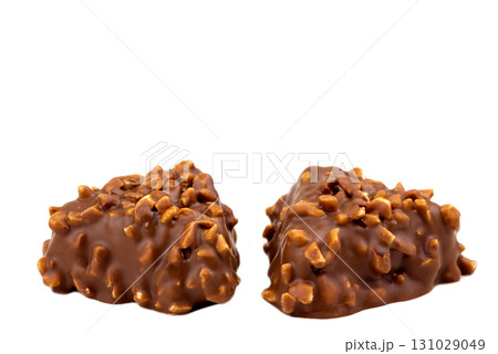Two pieces of chocolate with nuts on top Two pieces of chocolate with nuts on top 131029049