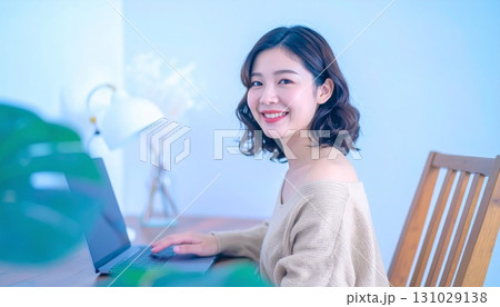 自宅でパソコンを使って仕事をする若い女性 自宅でパソコンを使って仕事をする若い女性 131029138