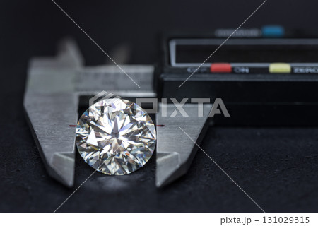 A diamond is being measured by a digital scale A diamond is being measured by a digital scale 131029315