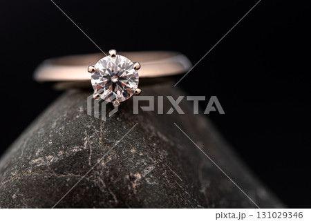 A diamond ring is sitting on a rock A diamond ring is sitting on a rock 131029346