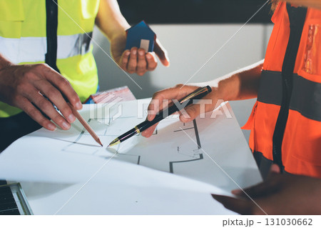 Closeup of team of industrial engineers meeting analyze machinery blueprints consult project on table in manufacturing factory. Working in manufacturing plant or production plant. Closeup of team of industrial engineers meeting analyze machinery blueprints consult project on table in manufacturing factory. Working in manufacturing plant or production plant. 131030662