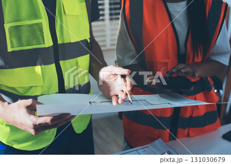 Closeup of team of industrial engineers meeting analyze machinery blueprints consult project on table in manufacturing factory. Working in manufacturing plant or production plant. 131030679