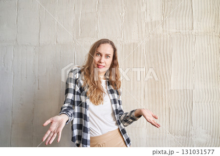 Caucasian woman in plaid shirt posing casually against textured wall Caucasian woman in plaid shirt posing casually against textured wall 131031577