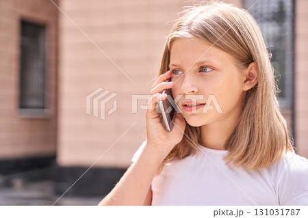 Young caucasian female teen talking on phone outdoors in casual setting Young caucasian female teen talking on phone outdoors in casual setting 131031787