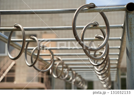 Empty playground monkey bars outdoors with metal rings in focus on a sunny day 131032133