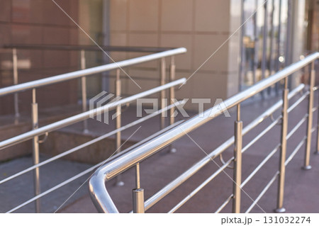 Modern stainless steel handrail on accessible ramp with reflective surface Modern stainless steel handrail on accessible ramp with reflective surface 131032274