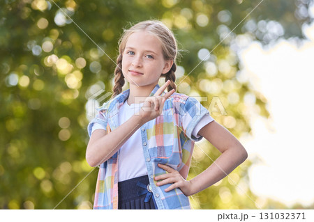 Caucasian young girl outdoors in casual outfit making peace sign gesture Caucasian young girl outdoors in casual outfit making peace sign gesture 131032371
