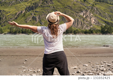 Caucasian adult female enjoying nature by river with arms outstretched in scenic Caucasian adult female enjoying nature by river with arms outstretched in scenic 131032425
