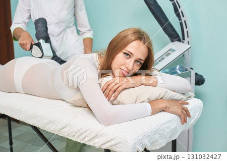 Young caucasian female receiving relaxing body contouring treatment at spa 131032427