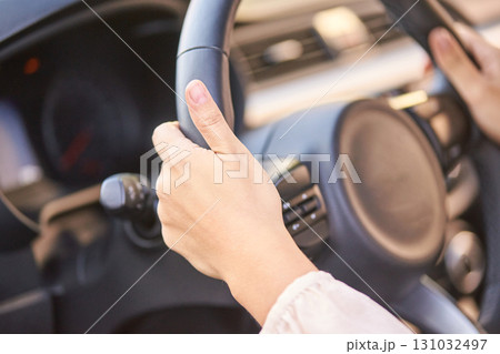 Female hands on steering wheel in car interior with sunlight reflection Female hands on steering wheel in car interior with sunlight reflection 131032497