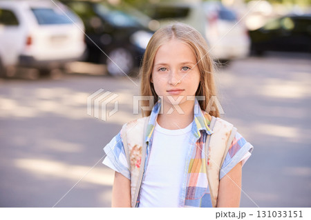 Blonde caucasian young girl with long hair wearing colorful shirt standing 131033151