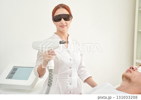 Female asian adult using laser equipment for male patient treatment in modern 131033208