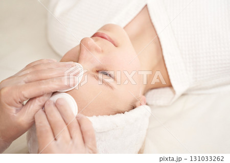 Young caucasian female receiving skincare facial treatment in a spa setting Young caucasian female receiving skincare facial treatment in a spa setting 131033262