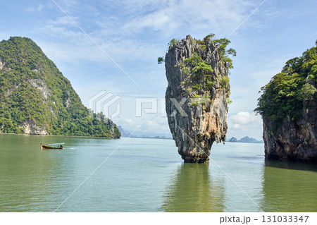 Stunning limestone karsts and traditional boat in phang nga bay, thailand 131033347