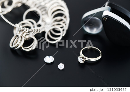 A ring and two diamonds are on a table A ring and two diamonds are on a table 131033485