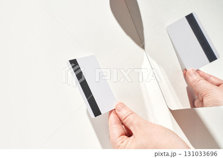Hands holding blank credit card with black stripe reflected in a mirror Hands holding blank credit card with black stripe reflected in a mirror 131033696