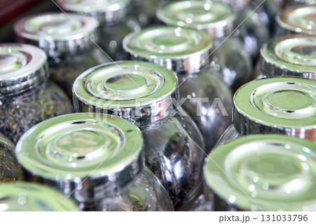 Close-up of glass jars with metal lids filled with various dried teas Close-up of glass jars with metal lids filled with various dried teas 131033796