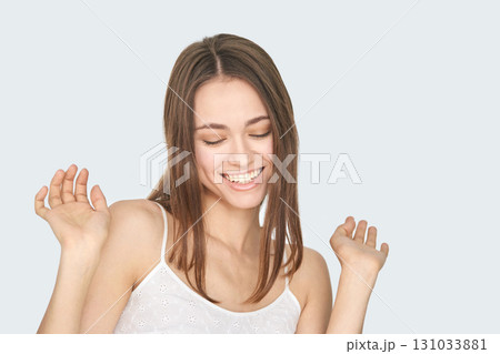 Smiling caucasian young female with long hair enjoying a happy moment in casual Smiling caucasian young female with long hair enjoying a happy moment in casual 131033881